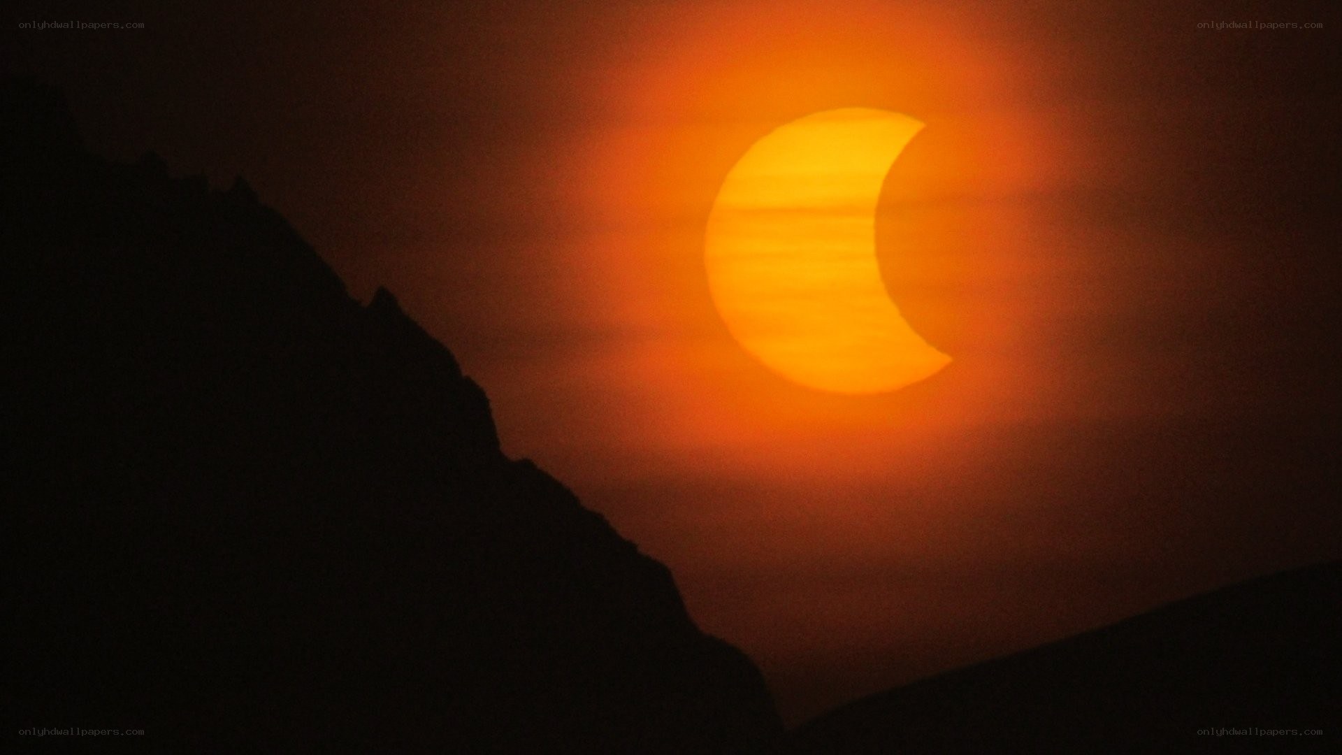solar eclipse over mountains