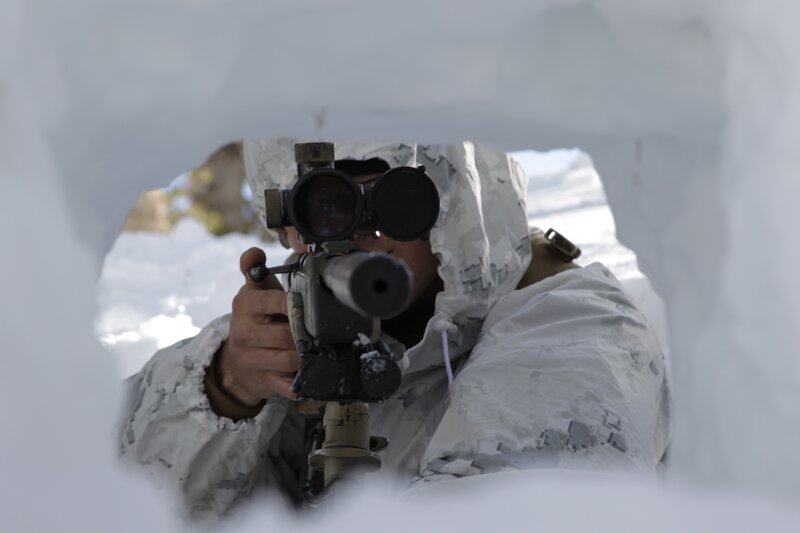 soldier aiming rifle from snow shelter