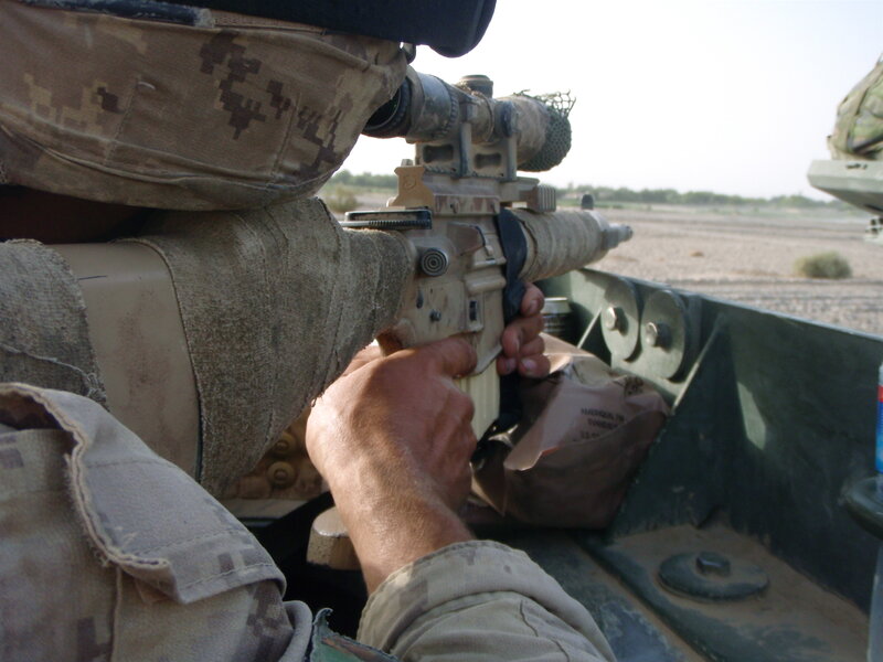 soldier aiming rifle from vehicle