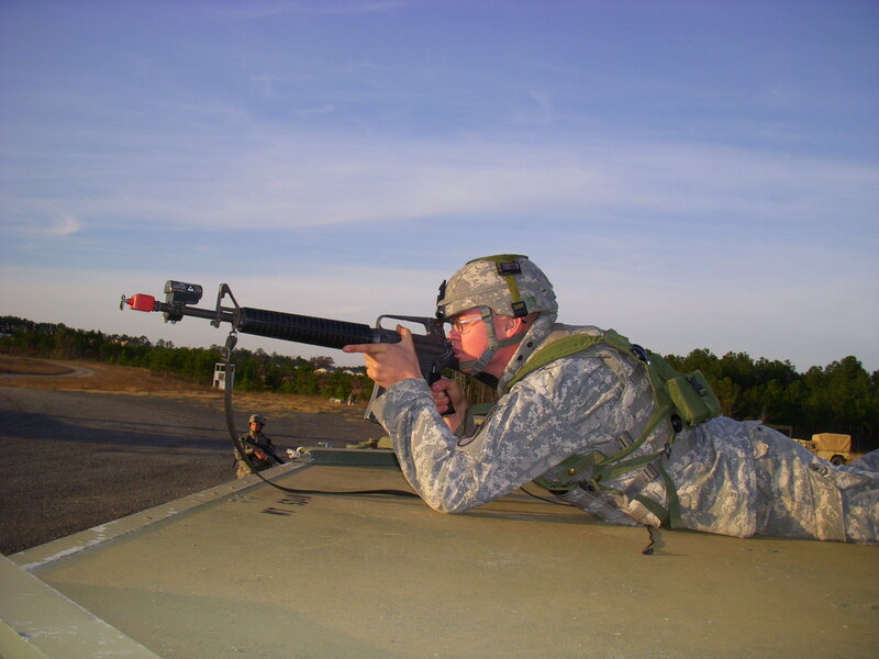Soldier aiming rifle from vehicle