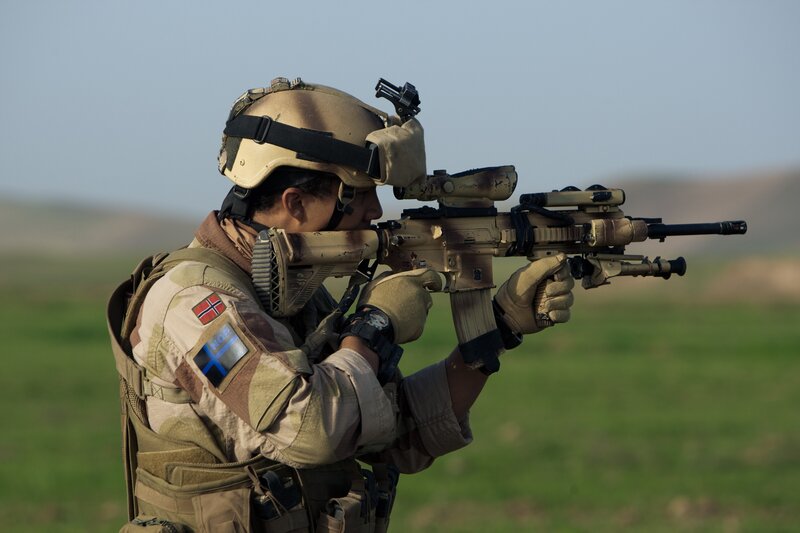 Soldier aiming rifle in field