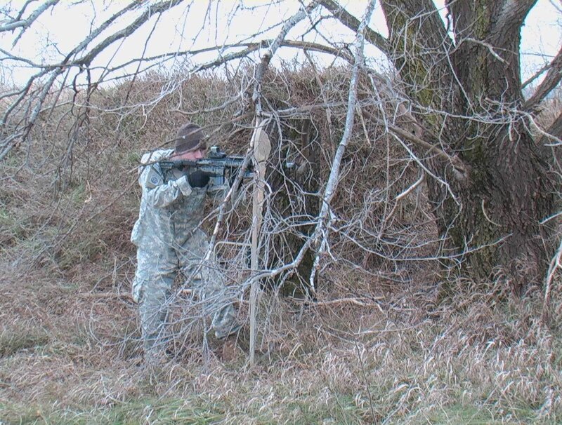 Soldier aiming rifle in woods