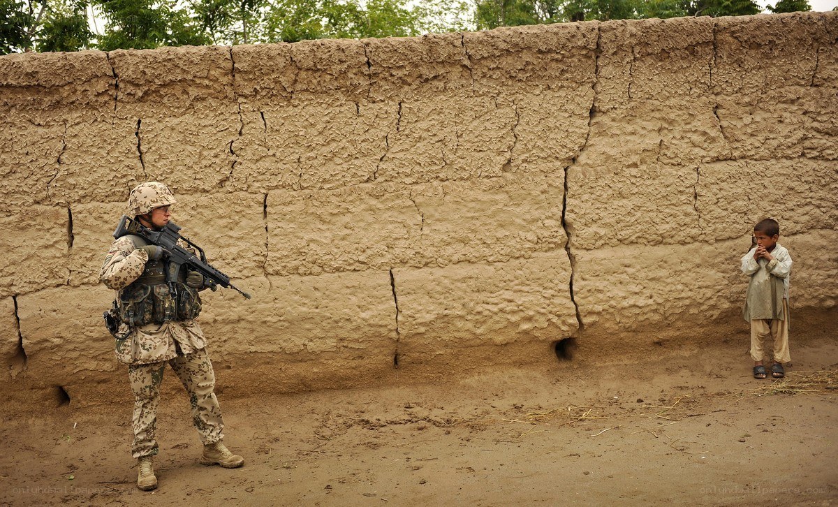 Soldier and child near mud wall