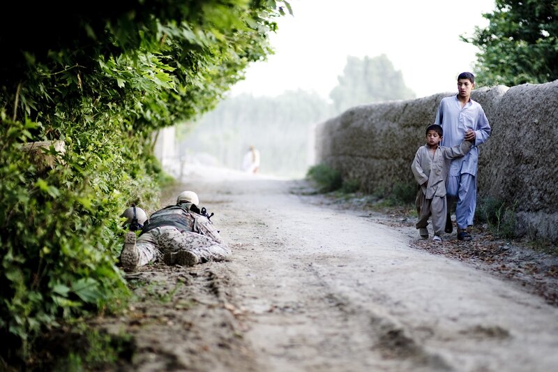 Soldier and children on a dirt road