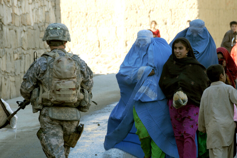 Soldier and civilians in a narrow street