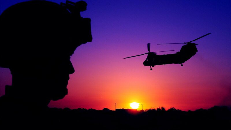 Soldier and helicopter at sunset