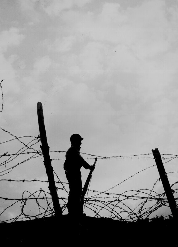 Soldier behind barbed wire