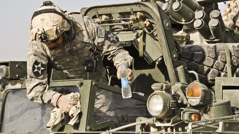 Soldier cleaning military vehicle