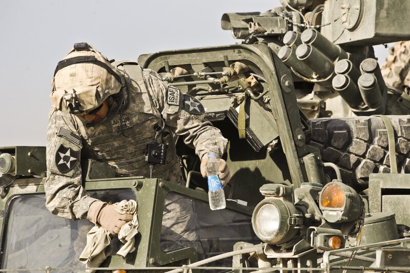 Soldier cleaning military vehicle