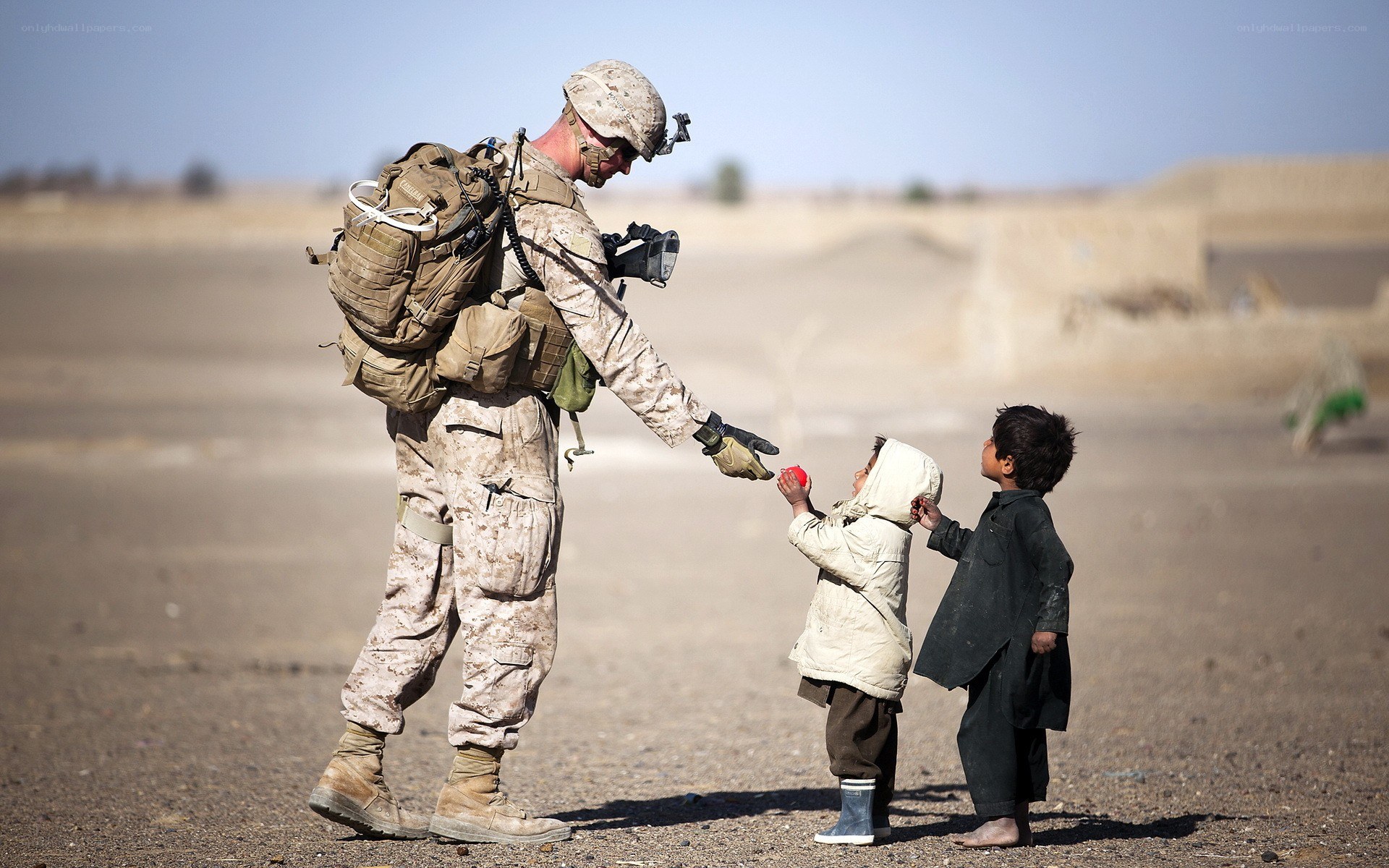 Soldier giving apple to children