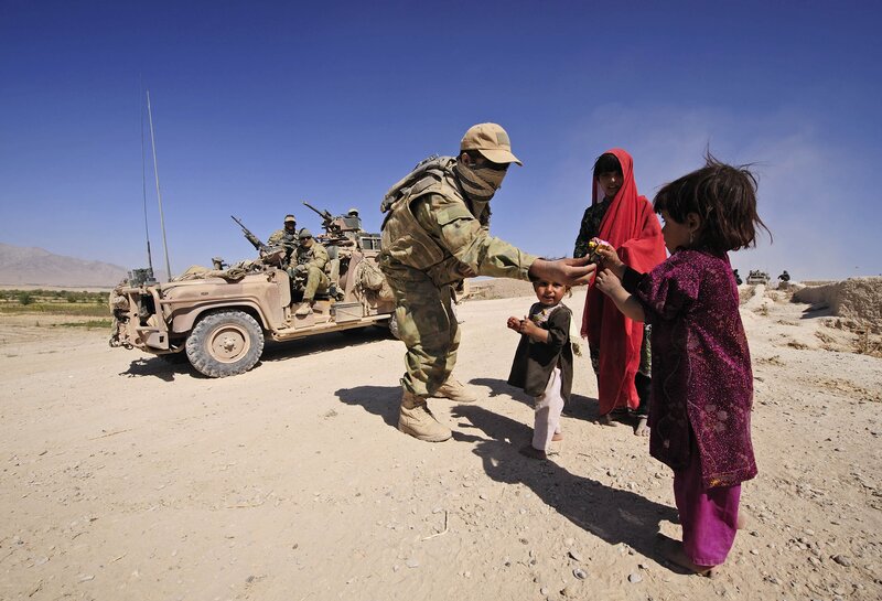 Soldier giving candy to children
