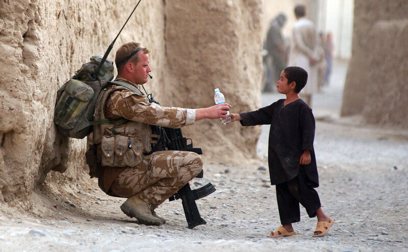 Soldier giving water to a child
