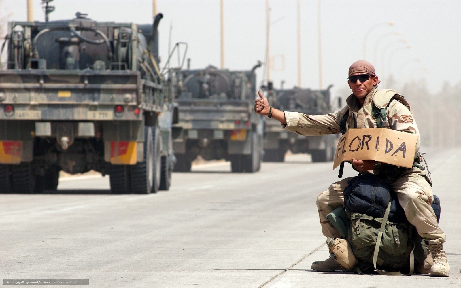 Soldier hitchhiking on road