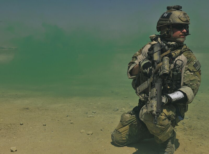 Soldier in combat gear with green smoke