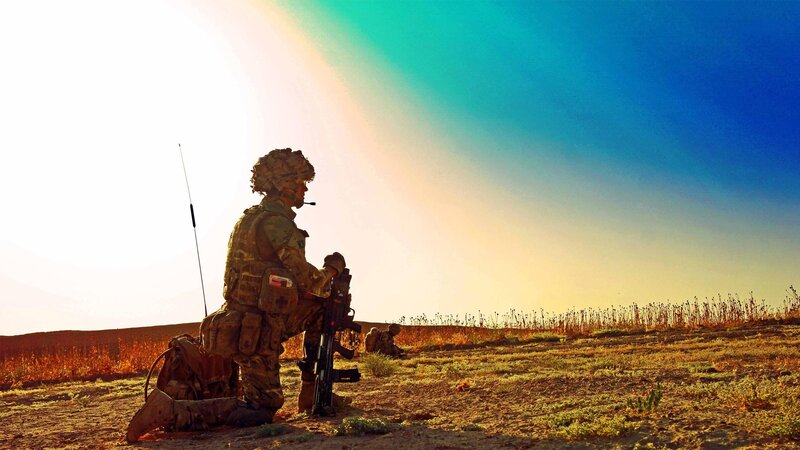 Soldier in desert at sunset