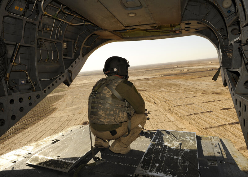 Soldier in helicopter over desert