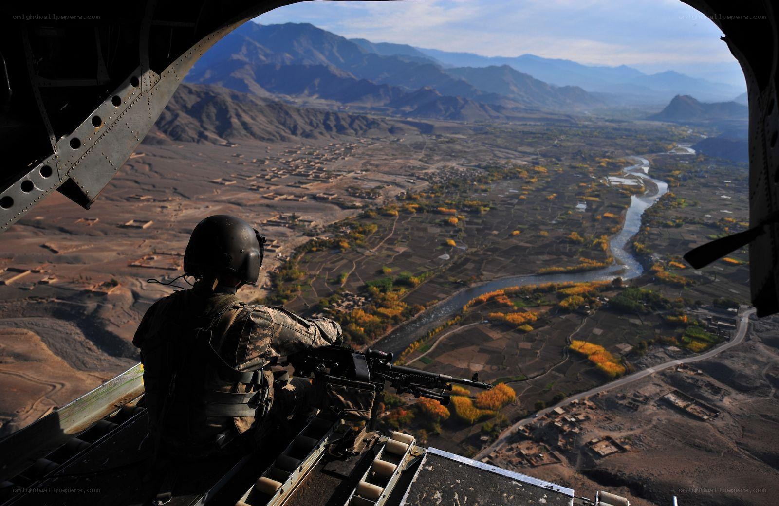 Soldier in helicopter over valley