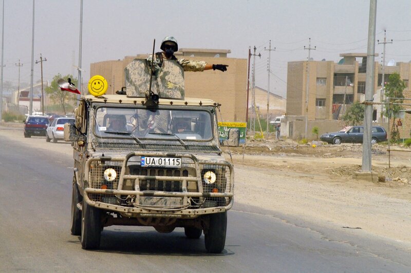 Soldier in military vehicle on road