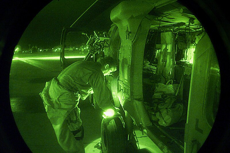 Soldier loading gear into helicopter