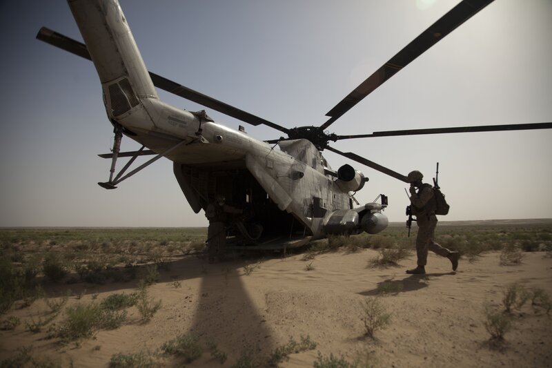 Soldier near helicopter in desert