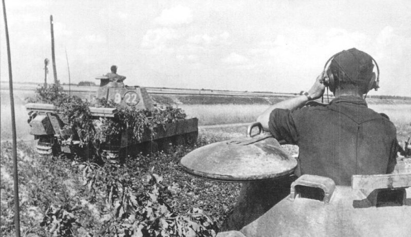 Soldier observing tank in field