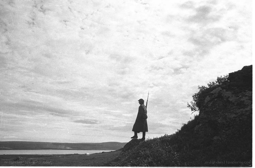 Soldier on a cliff overlooking water