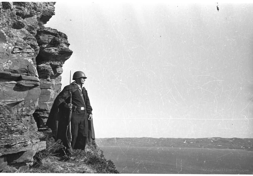 Soldier on a cliff overlooking water