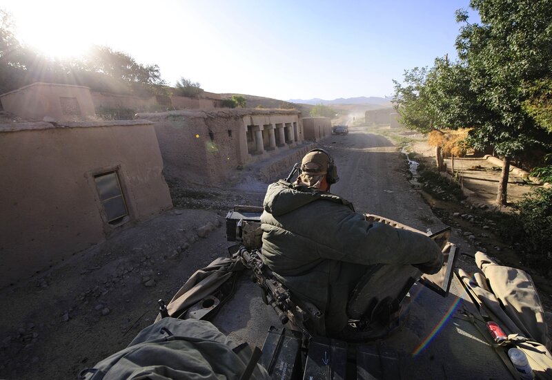 Soldier on a military vehicle in a village