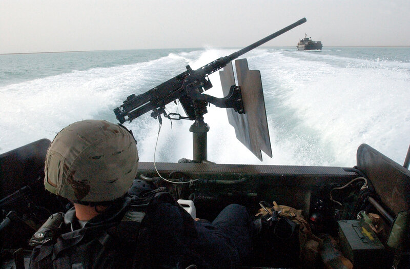 Soldier on a speedboat with machine gun