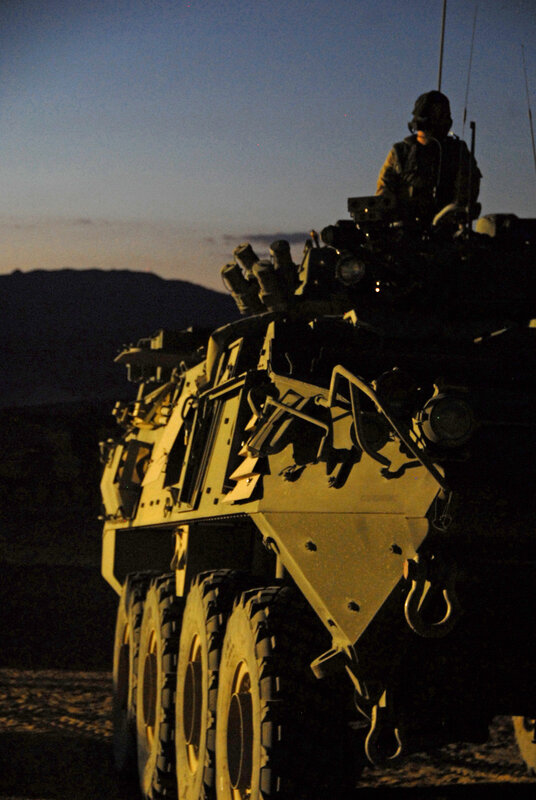 Soldier on armored vehicle at dusk