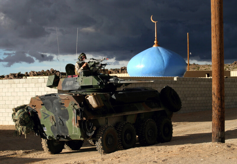 Soldier on armored vehicle near mosque