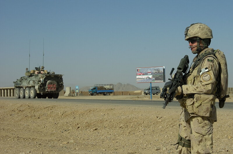 Soldier on patrol with armored vehicle
