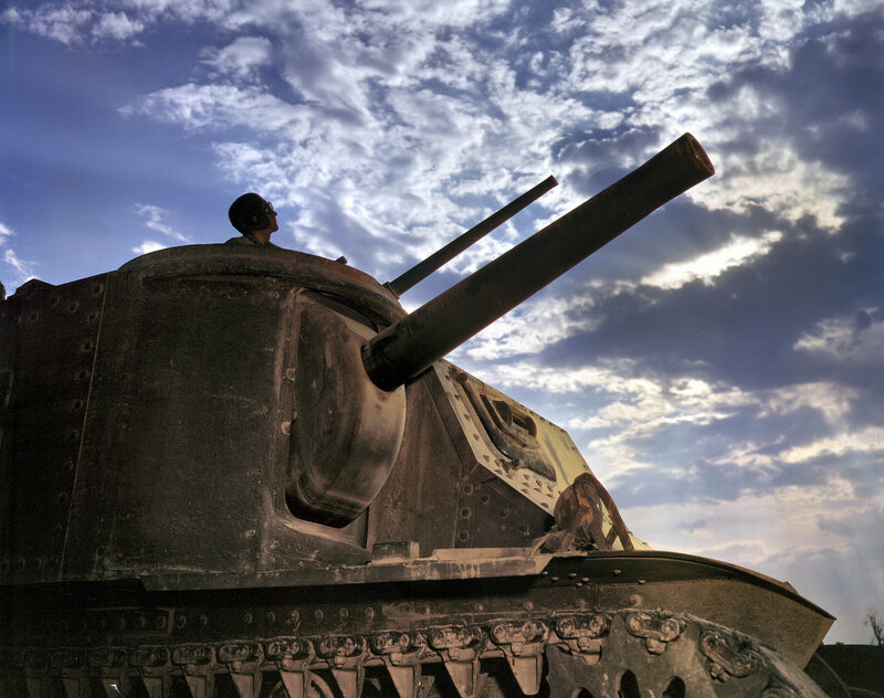 Soldier on tank under cloudy sky