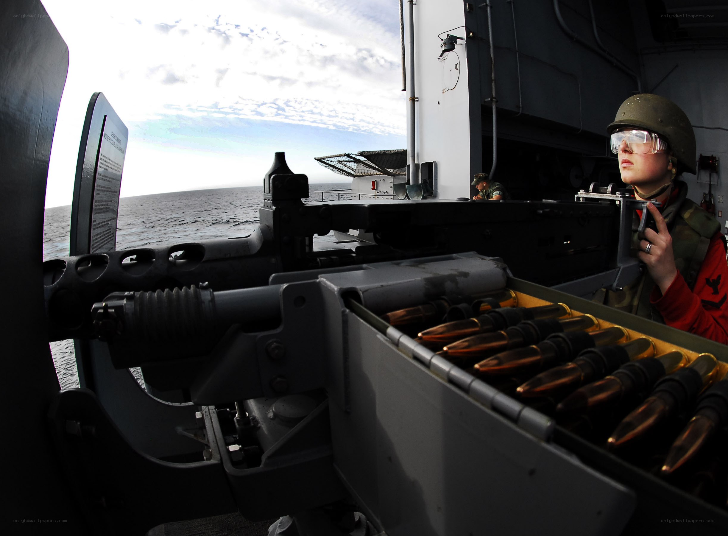Soldier operating machine gun on ship