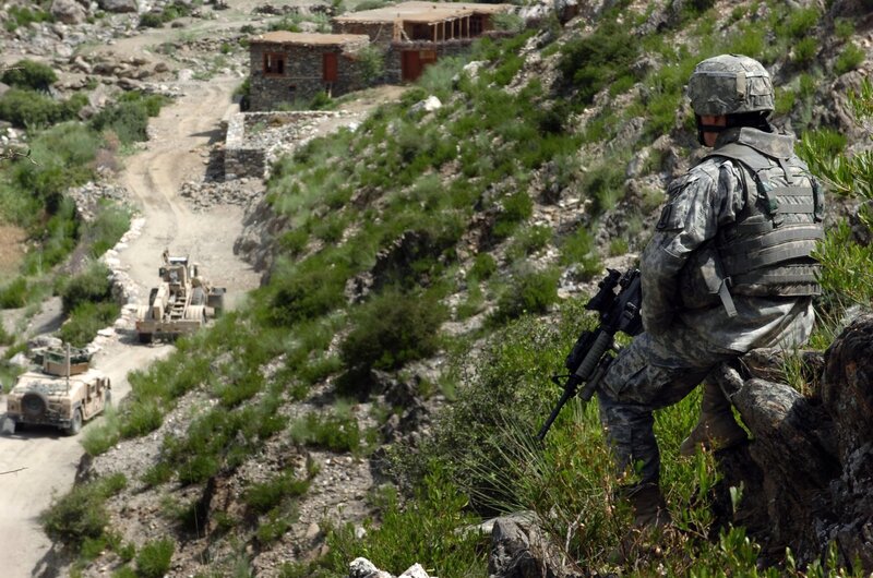 Soldier overlooking military convoy
