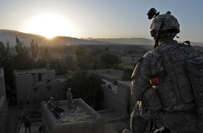 Soldier overlooking village at sunset