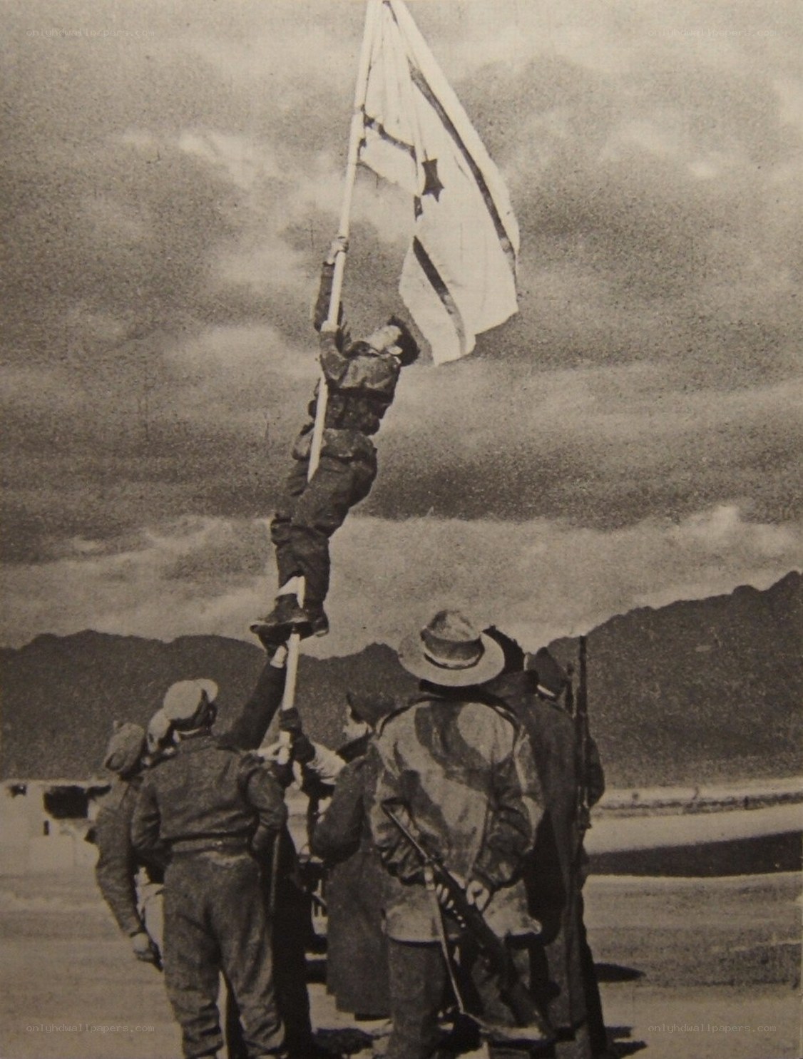 Soldier raising flag on a pole