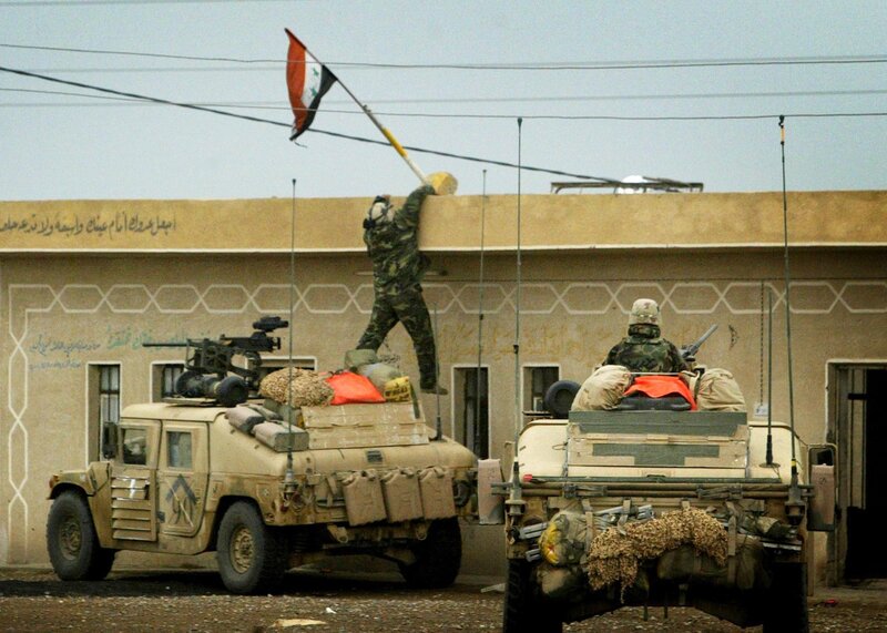 Soldier raising flag on building