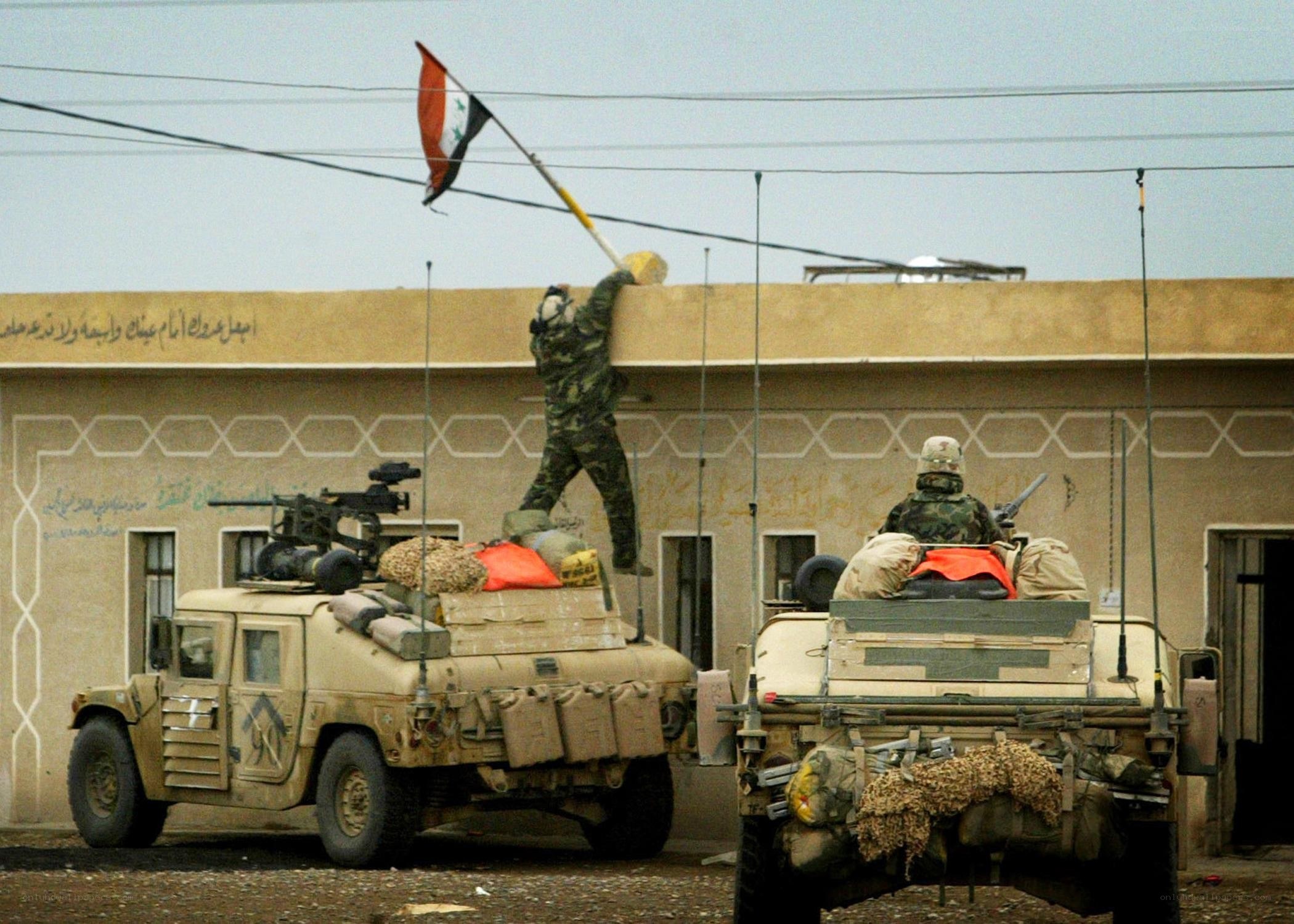 Soldier raising flag on building