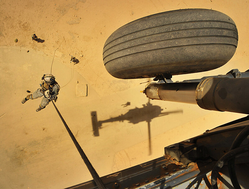 Soldier rappelling from helicopter