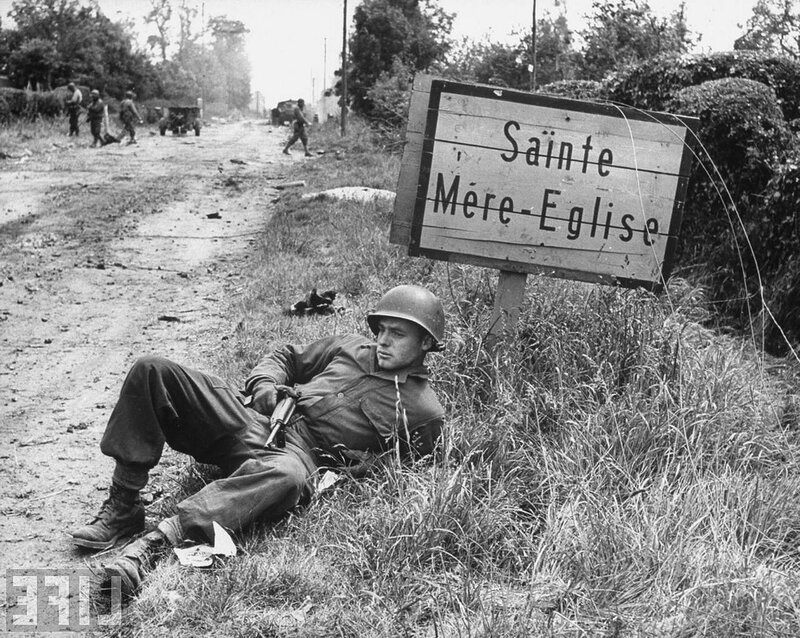 Soldier resting near village sign