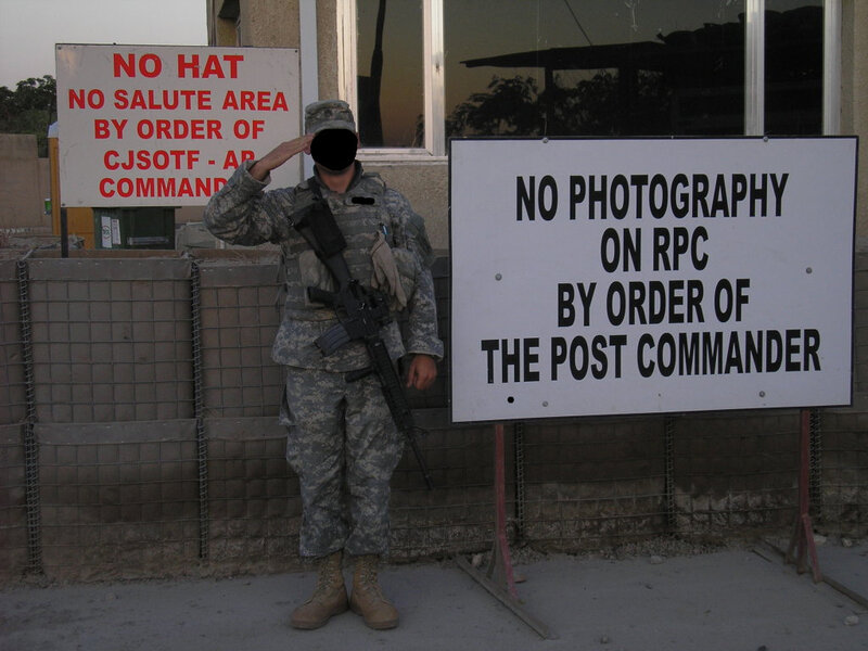 Soldier saluting near signs