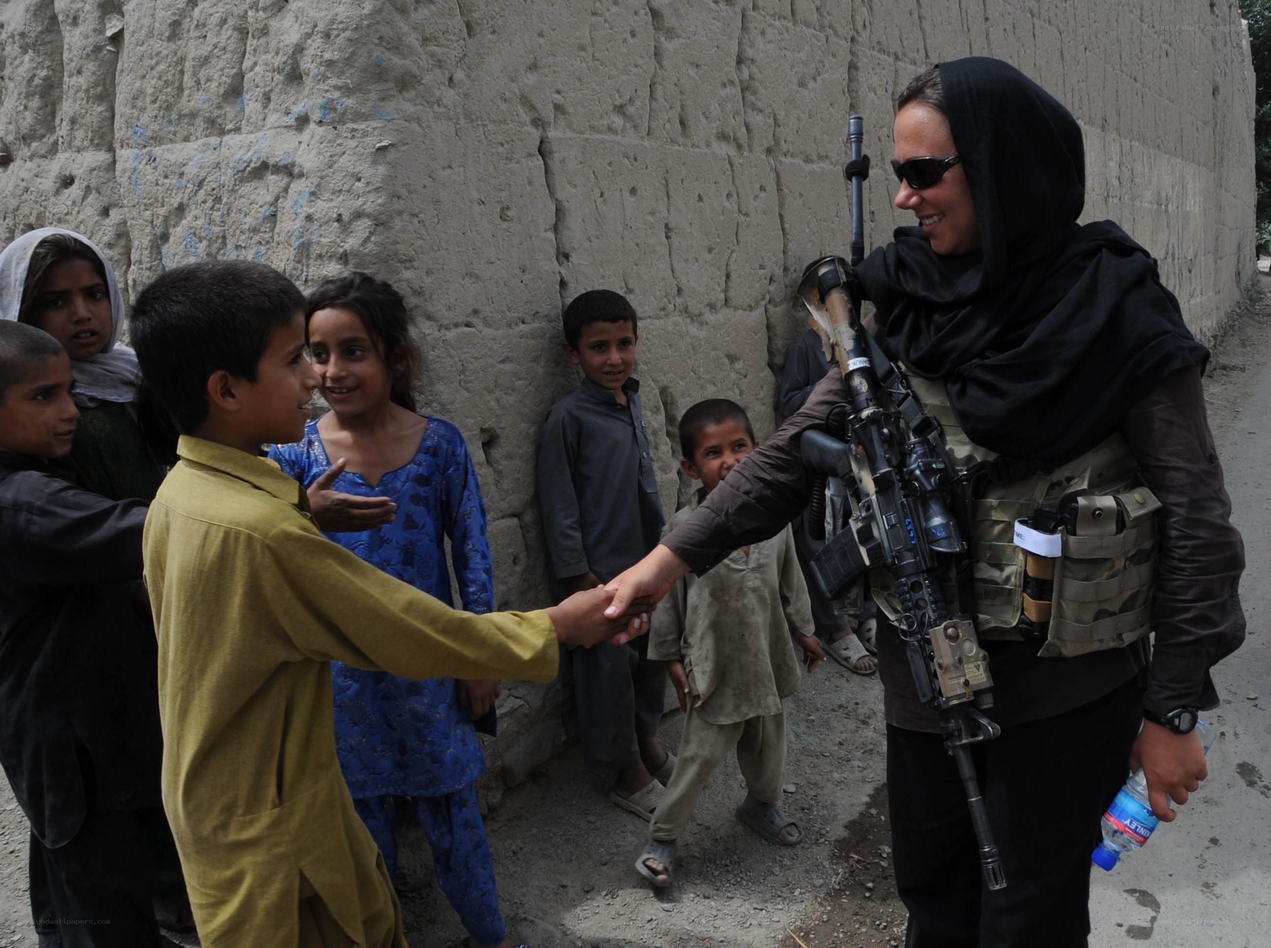 Soldier shaking hands with children
