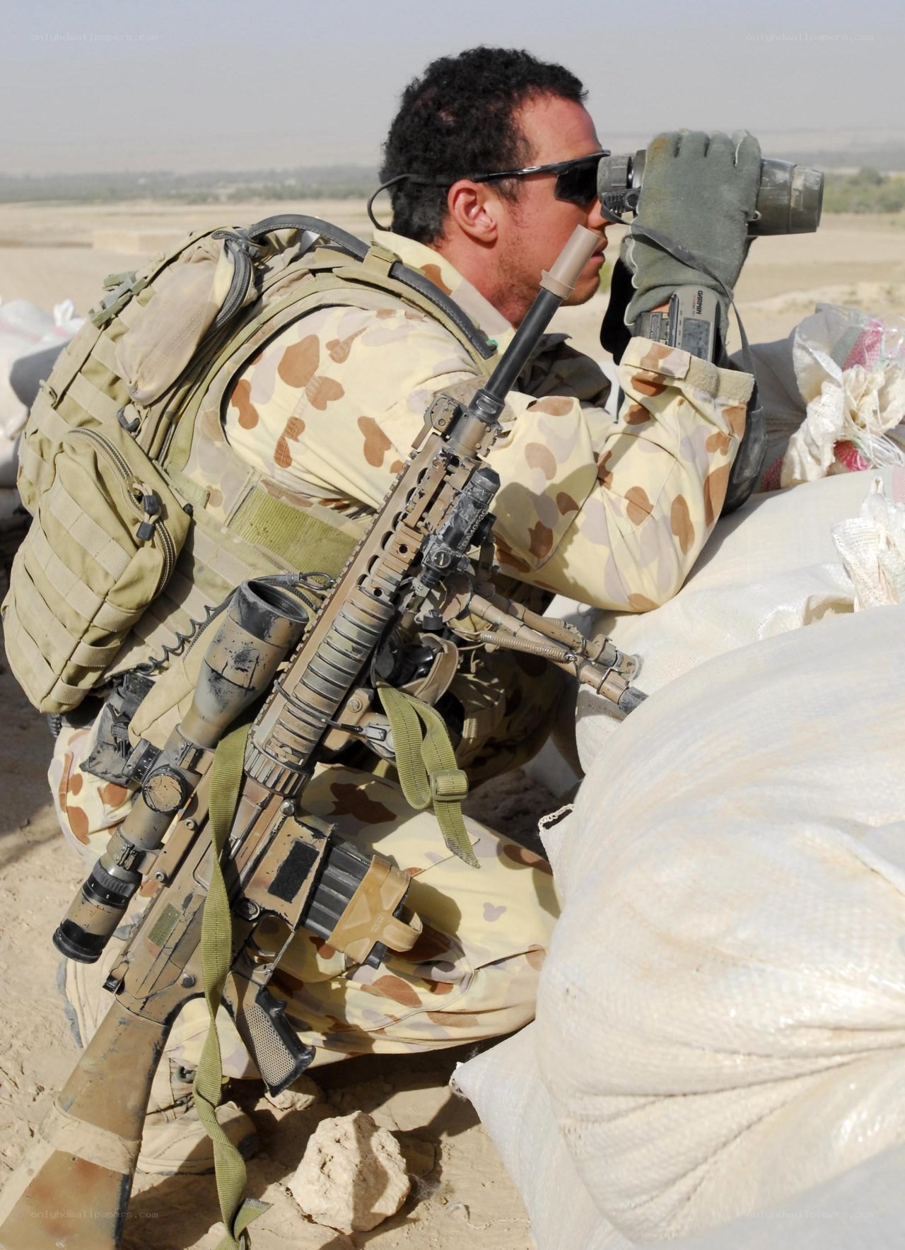 Soldier using binoculars in desert