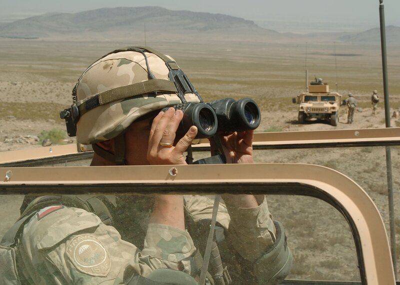 Soldier using binoculars in desert