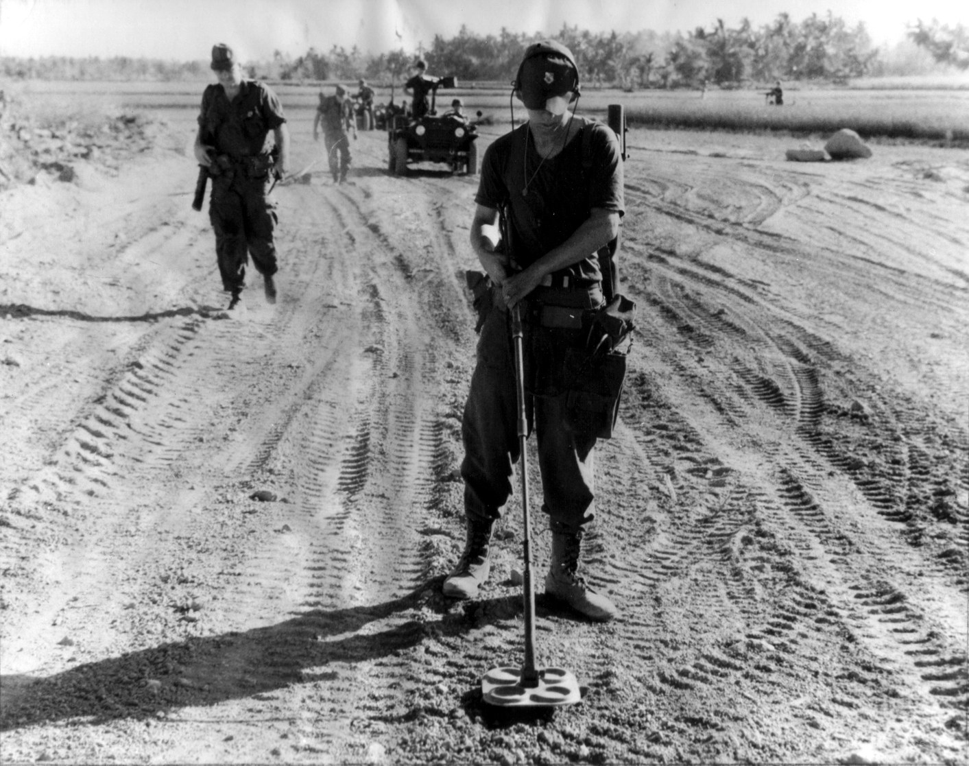 Soldier using metal detector in field