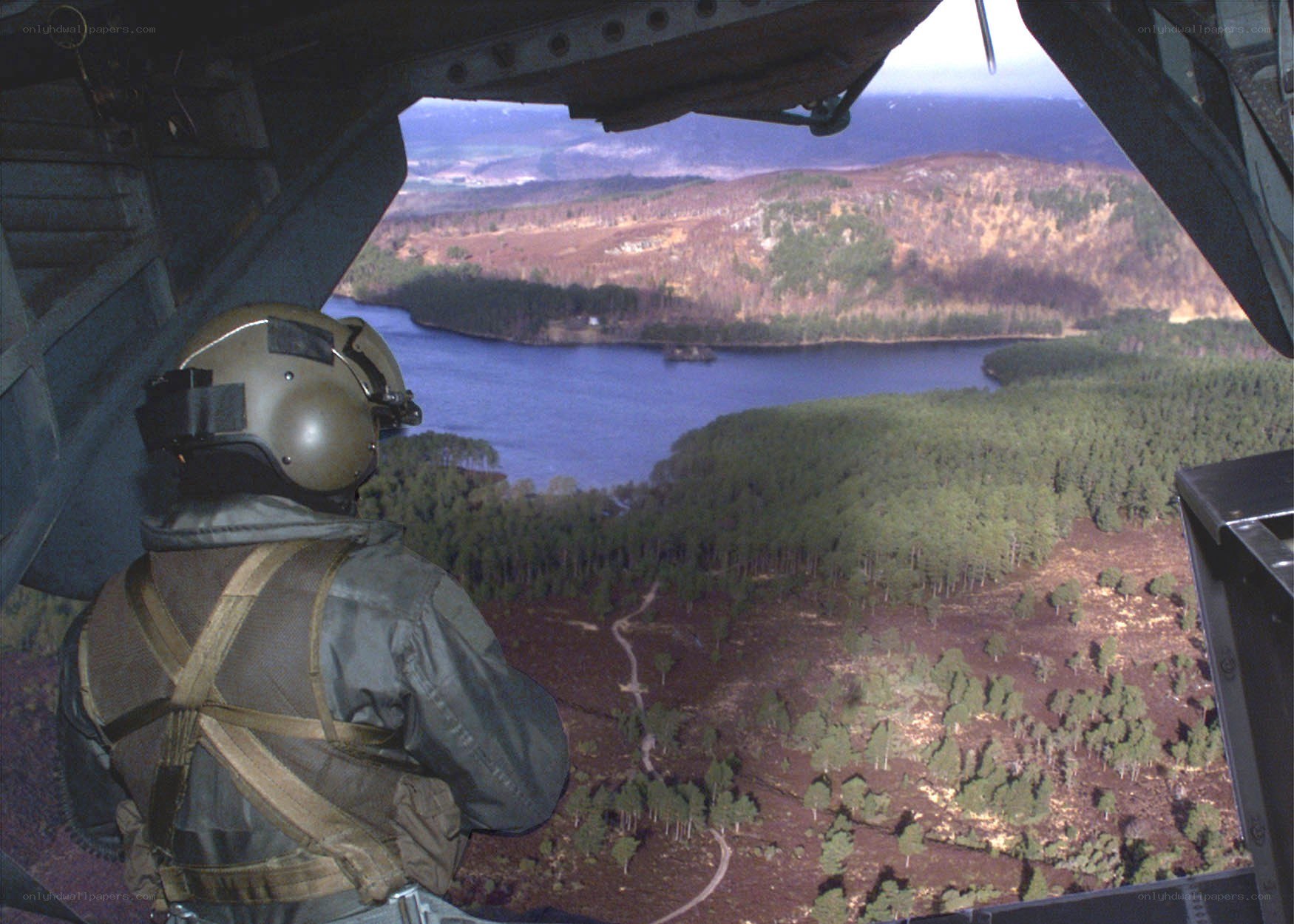 Soldier views landscape from helicopter