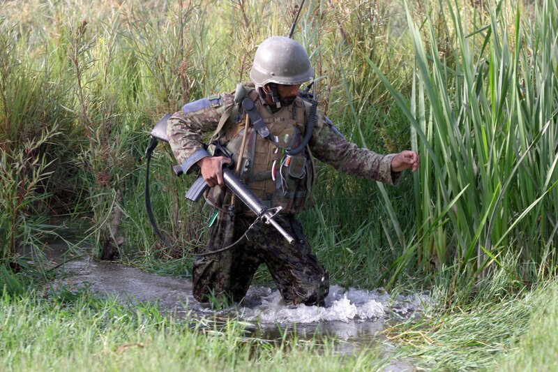 Soldier wading through a stream