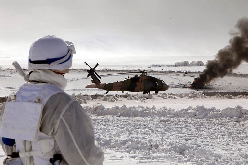 Soldier watches helicopter in snow