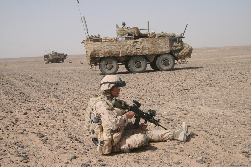 Soldier with armored vehicle in desert